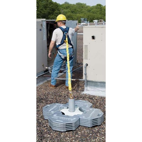 DBI/Sala Anchor Freestanding Counterweight, worker wearing safety gear setting up the counterweight for secure anchoring of fall protection systems on a rooftop.