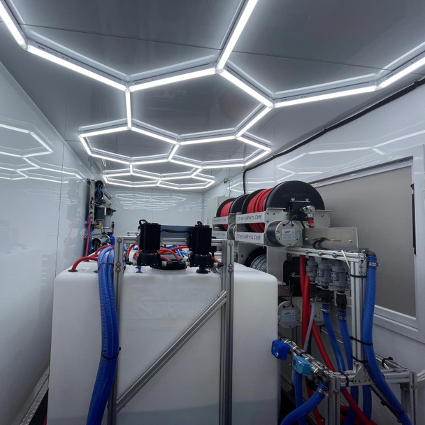 ProTool Enclosed Pressure and Soft Washing Drone Trailer, interior view showing pressure washing equipment with hoses and control units inside a well-lit enclosed trailer.