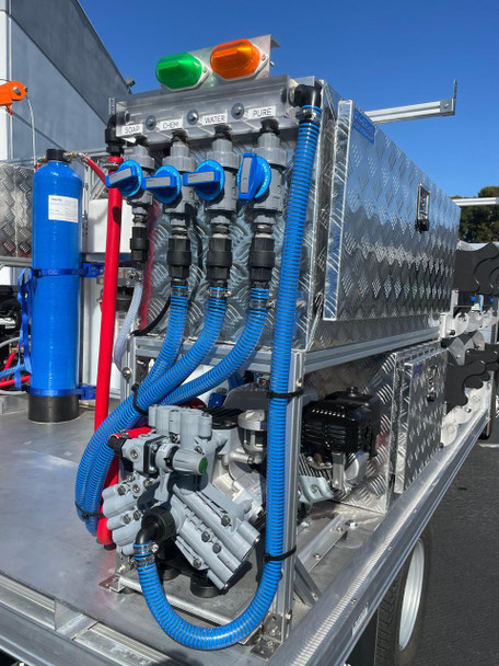 ProTool Drone Flatbed Skid - V-SPEC, close-up of the stainless steel flatbed skid with chemical, soap, water and pure-water controls, blue hoses, pump, and storage compartments.