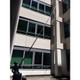 Gardiner Pole Systems Gardiner Ultimate 79ft Tele Pole HM Carbon Kevlar, extending pole reaching the top of a building for maintenance or cleaning.