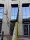 Gardiner Pole Systems Gardiner Ultimate 90ft Tele Pole HM Carbon Kevlar, tall telecommunication pole extending to the top of a modern building.