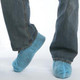J.Racenstein Shoecover Skid Resistant, pair of blue skid-resistant shoe covers worn over regular shoes by a person standing on a smooth surface.