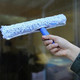 Ettore Professional Window Cleaning Kit, hand holding a window squeegee with a microfiber cleaning pad for efficient glass cleaning.
