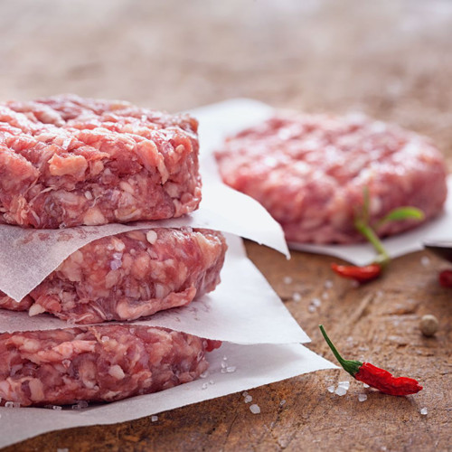 Four beef burgers, prepped and ready to cook