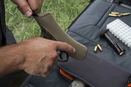 slidboot being applied to a firearm slide at the range.