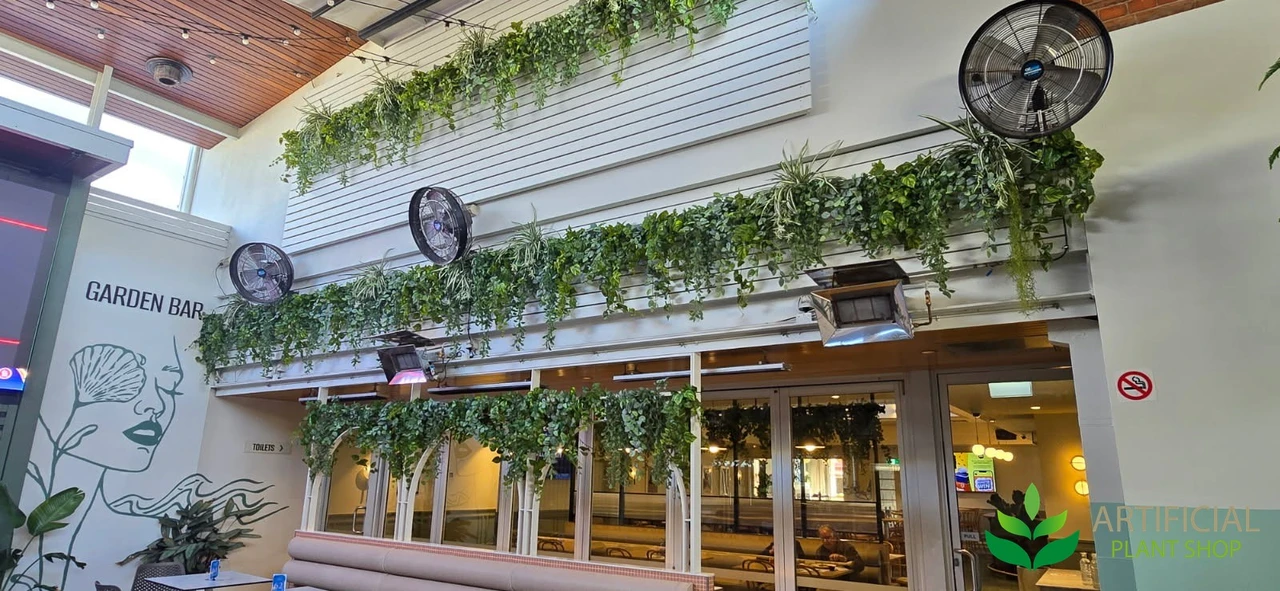 three long runs of artificial hanging greenery kits across a garden bar wall