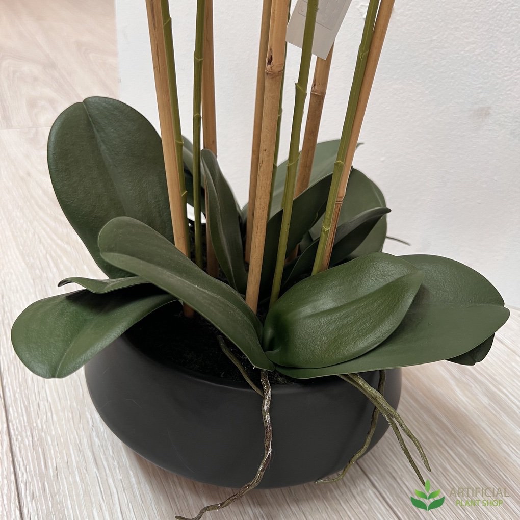 faux orchid leaves in a black pot