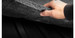 Hand lifting the edge of the Guardian Comfort liner to show its cushion