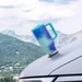 Silwy tumbler stuck to a car hood, mountains behind