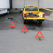 Three warning triangles set out behind a stopped pickup