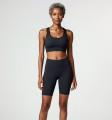 Front view of a model wearing the Anuri Powerform Padded Sports Bra in Ebony with black contrast trim and matching high-waisted shorts.