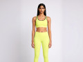 Front view of a model wearing the Anuri Powerform Padded Sports Bra in Lemon Grass with black contrast trim.