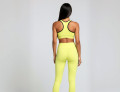 Back view of a model wearing the Anuri Powerform Padded Sports Bra in Lemon Grass with black contrast trim.