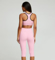 Back view of a model wearing the Anuri PowerForm Padded Sports Bra in Primrose Pink with black contrast trim and matching high-waisted shorts.