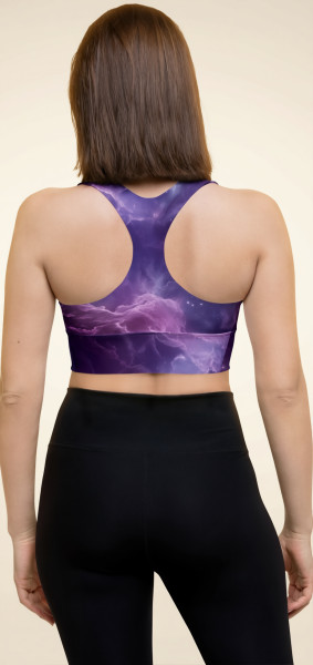 Rear view of a model wearing the Anuri Flow Recycled Longline Sports Bra in a cosmic purple abstract print, showing the supportive racerback cut and extended compression underband.