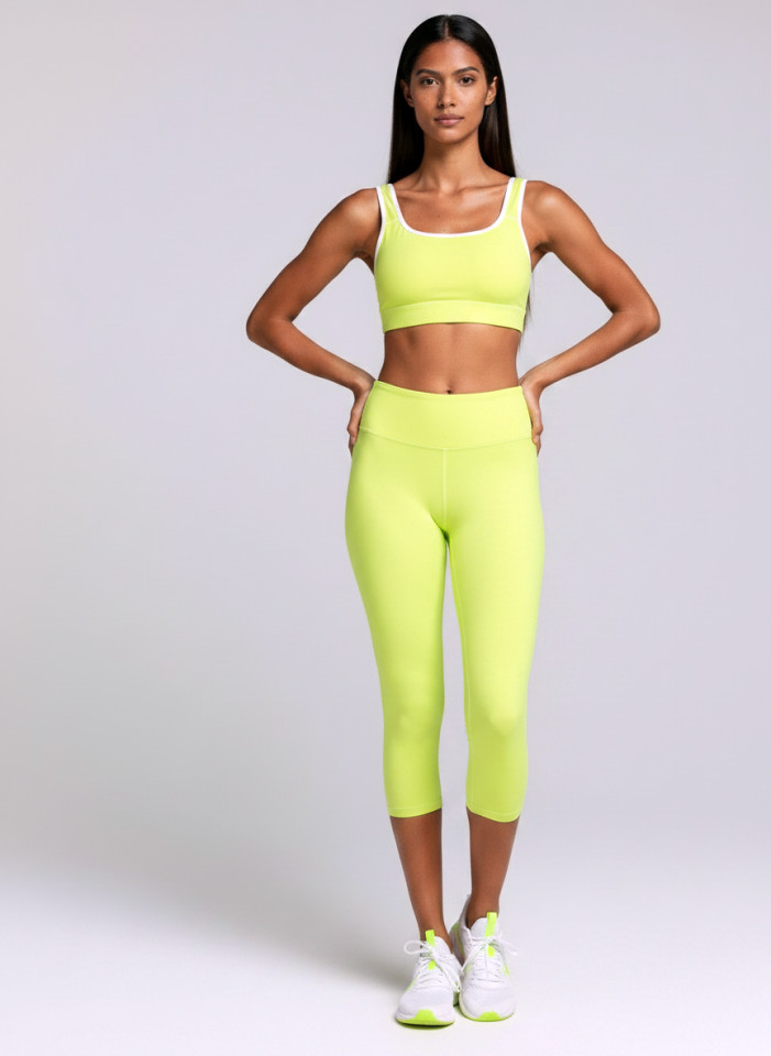Front view of a model wearing the Anuri Powerform Padded Sports Bra in Lemon Grass with white contrast trim.