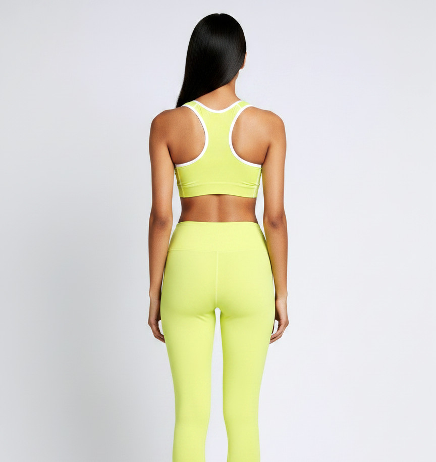 Back view of a model wearing the Anuri Powerform Padded Sports Bra in Lemon Grass with white contrast trim.