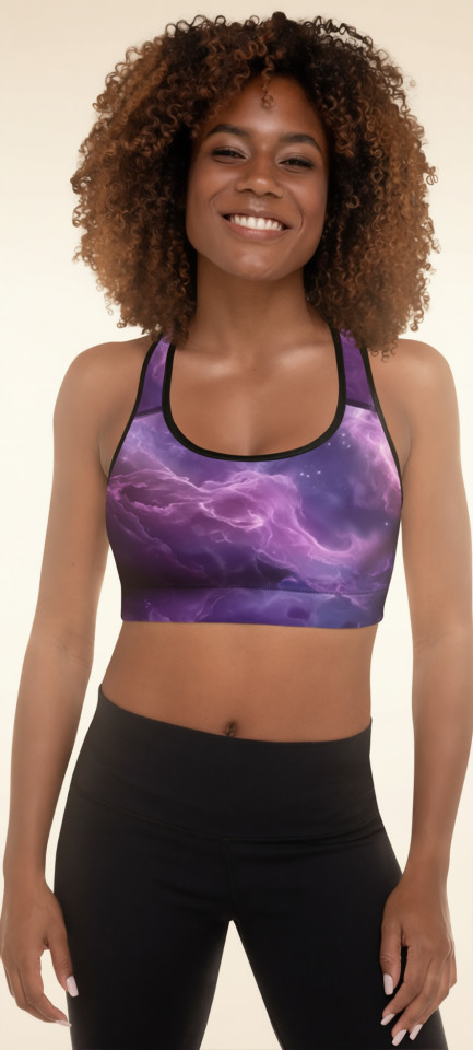 Front view of a smiling model wearing the Anuri Flow Padded Sports Bra in a cosmic purple abstract print featuring a scoop neckline and black trim.