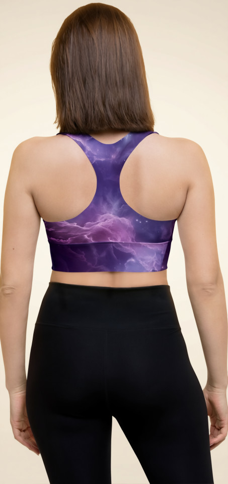 Rear view of a model wearing the Anuri Flow Recycled Longline Sports Bra in a cosmic purple abstract print, showing the supportive racerback cut and extended compression underband.