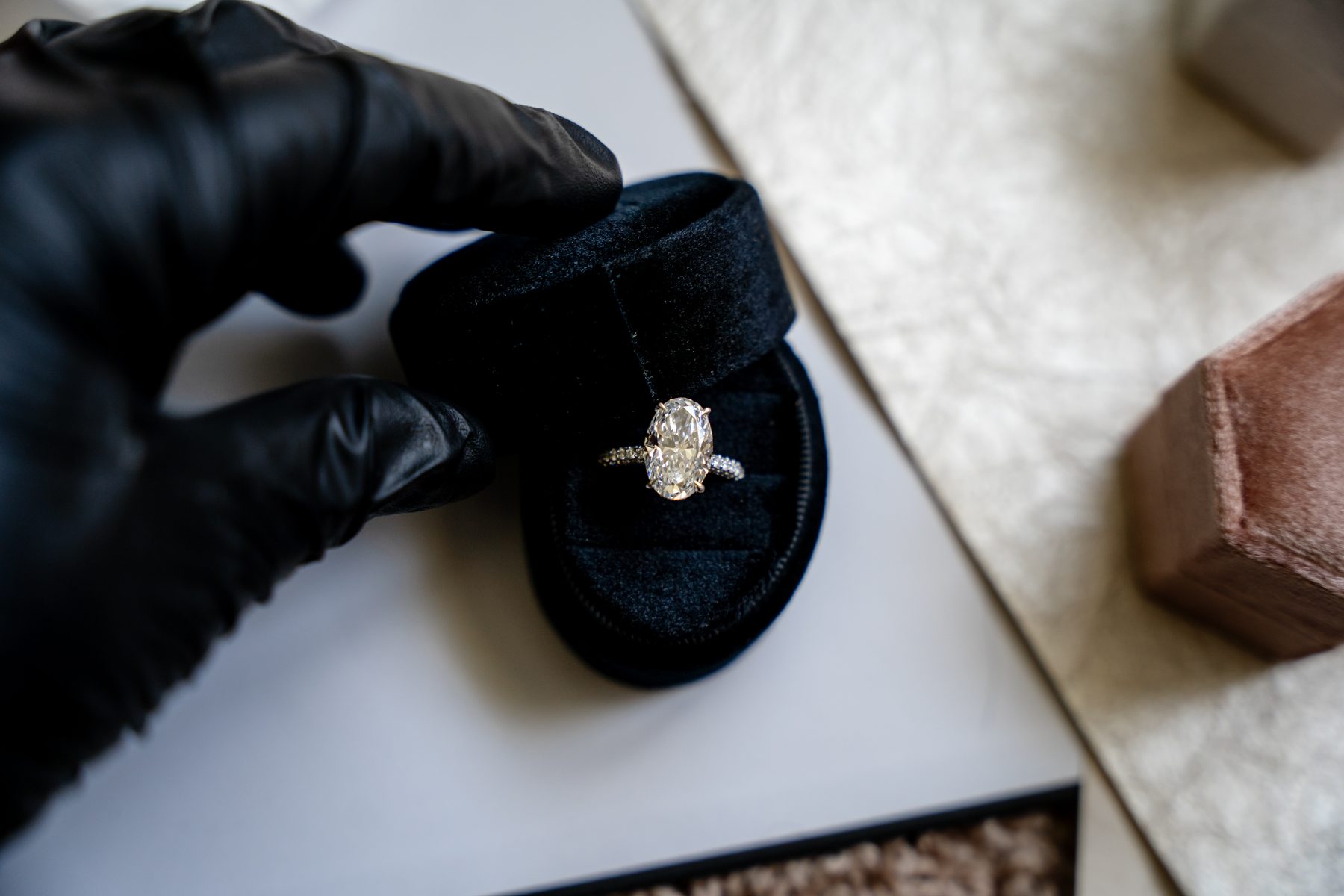 Finished diamond ring held with a black glove