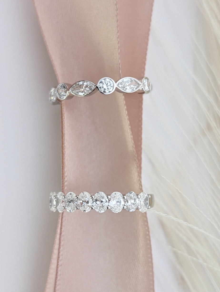 Two custom diamond wedding bands on pink ribbon