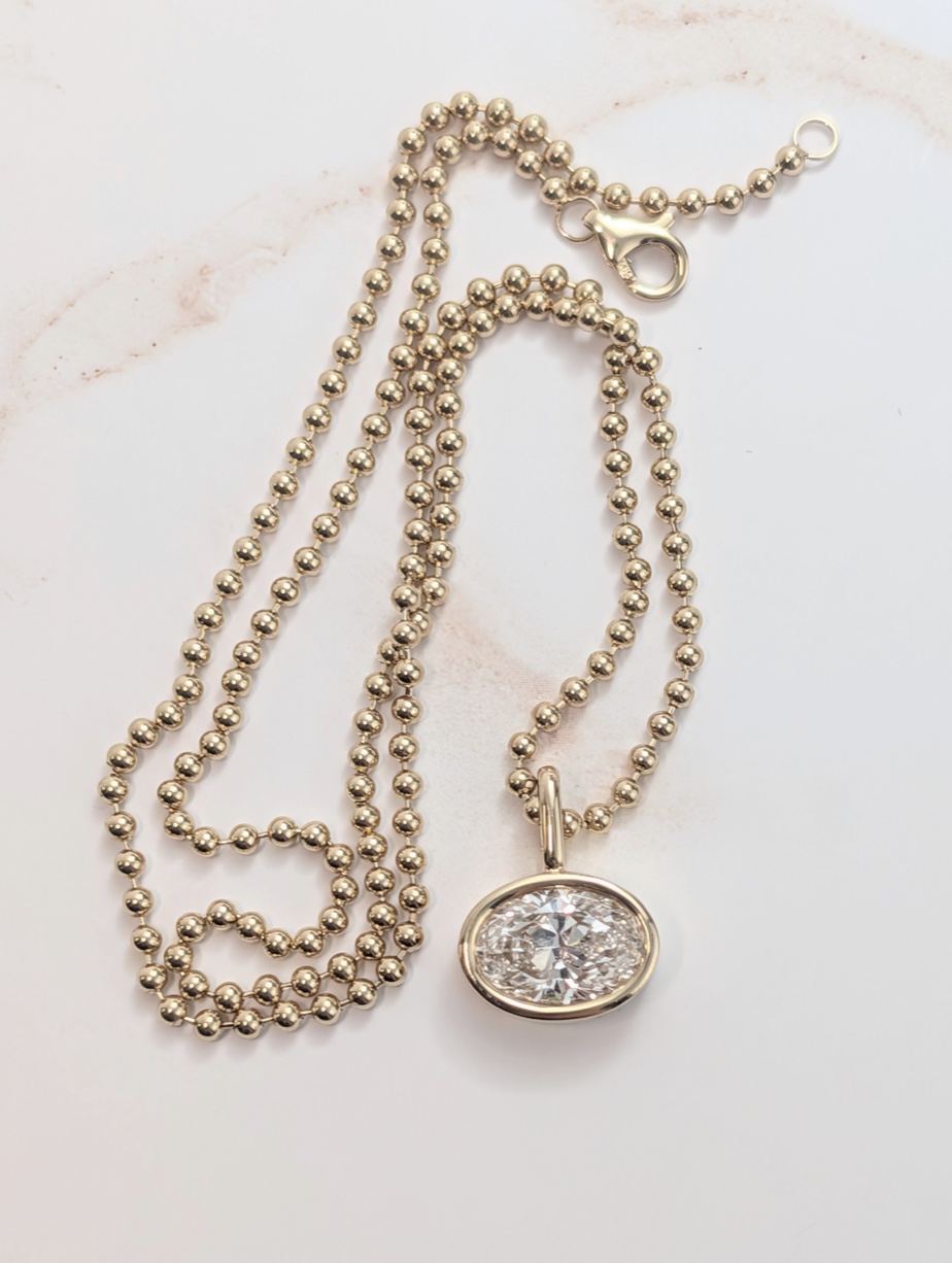 Diamond pendant on a yellow-gold ball chain