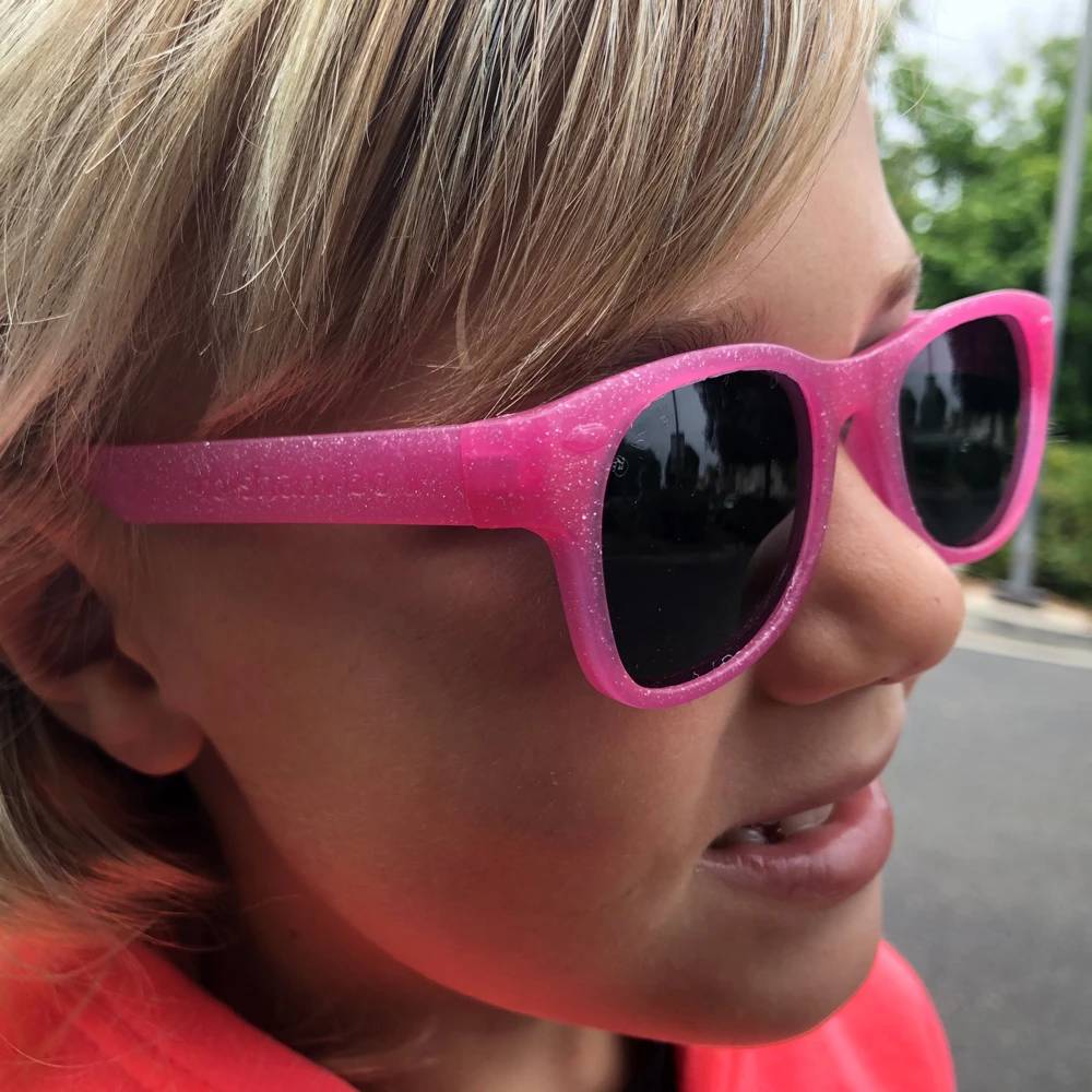 polarized junior shades, kelly glitter pink, girl wearing shades side view