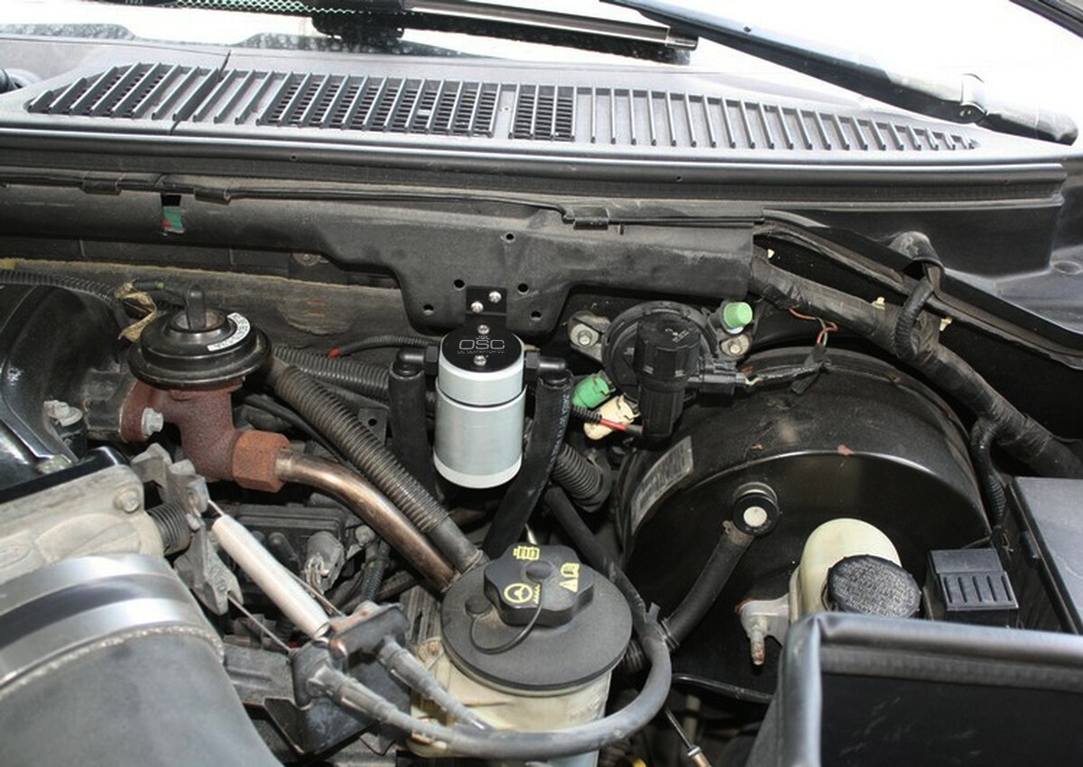 J&L Oil Separator 3.0 Driver Side (1999-2004 Ford F-150 Lightning; 2002-2003 F-150 Harley Davidson) unit mounted in truck engine compartment.