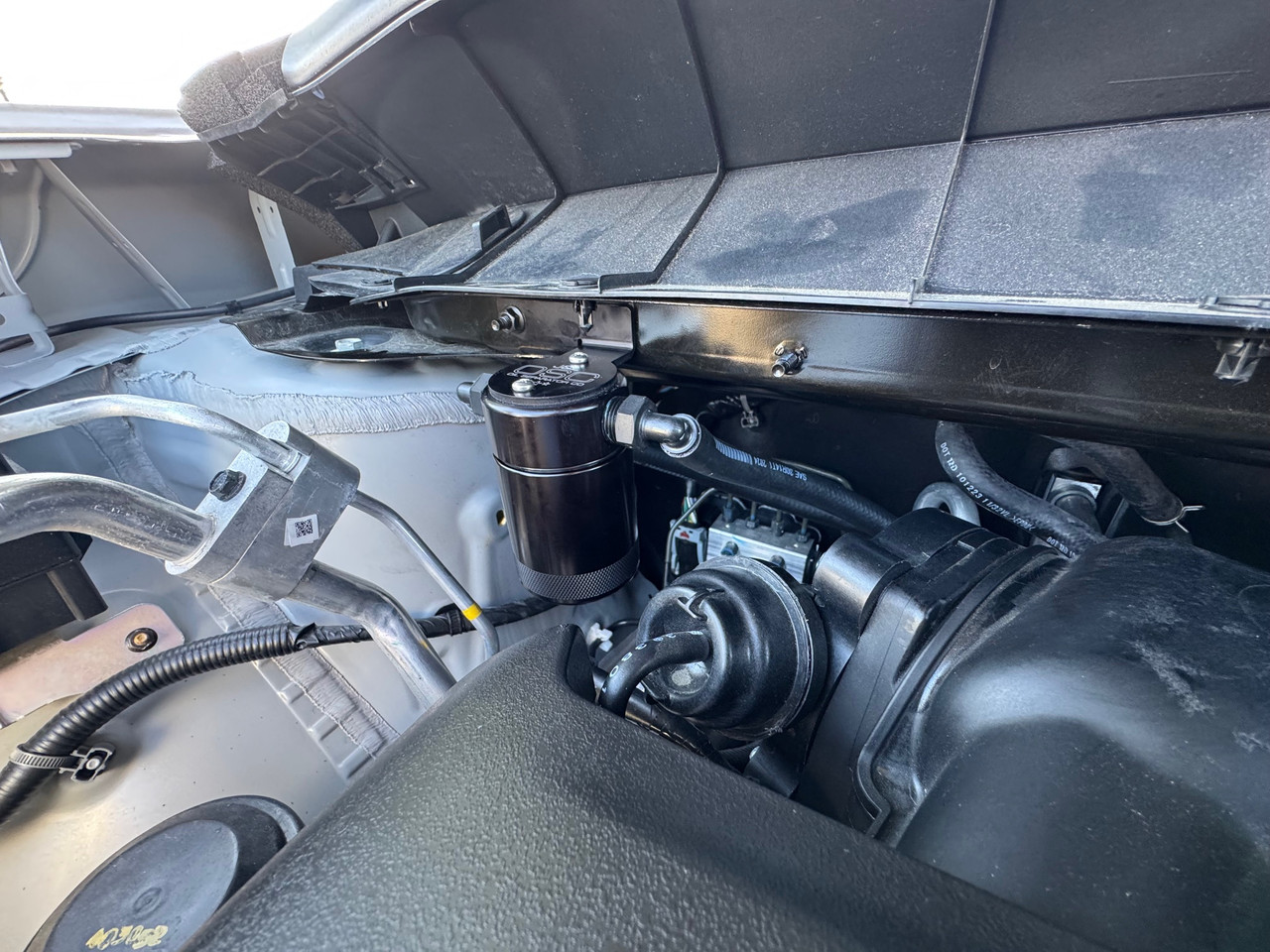 J&L Oil Separator 3.0 PCV Side (2022-2025 Nissan Pathfinder; 2022-2024 Infiniti QX60 3.5L)  unit mounted in the engine compartment.