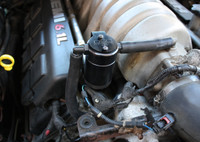 J&L Oil Separator 3.0 Passenger Side (2005-2010 6.1L Hemi SRT8 Dodge Charger, Challenger, 300C, Magnum & Jeep) unit mounted in vehicle engine compartment.
