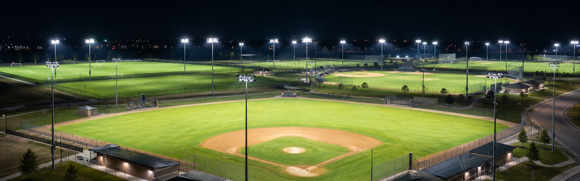 LED sports lights on poles illuminate an empty athletic field at night with uniform, bright coverage for safe recreational and competitive play.