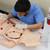 Student observing thoracic cavity of nursing manikin