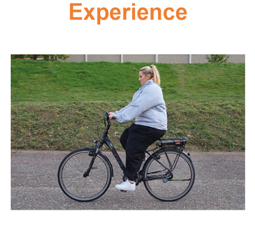 A picture of a women on a bike wearing our Adipositas Trainer / Obesity Simulator