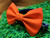 Solid orange handmade pet bow tie with double elastic loops for dog collar attachment