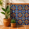 Decorative wall with "Dolores" Talavera tiles in blue, yellow, and red tones, flanked by terracotta potted plants.