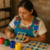artisan painting a 4×4‑inch Talavera tile by hand, applying vibrant blue glaze to intricate floral scroll motifs in her workshop.