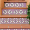 Outdoor stair risers decorated with lavender daisy Talavera tiles and terracotta steps.