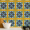 Kitchen backsplash with "Colonial Sun" Talavera tiles featuring blue flowers and green leaves, next to a stove and mixing bowl.