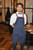 Dearborn Cross Back Apron shown in navy with chili pepper red contrast ties and stitching