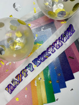 Image of twelve Sparkle sheets aligned below a white sash using all 12 colors of Sparkle, layered to create a two-tone effect reading “Happy Birthday”.