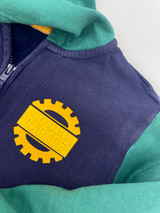 Image of a blue child’s sweatshirt with green sleeves showing a yellow rectangular name sign reading “Jordan’s Garage” using Brick 600 that’s part of a gear design using yellow EasyWeed Stretch which covers the entire design.