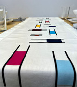 Close up of an image of a linen-colored table runner with a Piet Mondrian-like design shopping symmetrical color blocks using Stripflock Pro with place settings and cutlery surrounding the table runner.