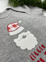 Image of a cropped gray baby onesie with a Santa’s beard and hat using white StripFlock Pro with red/white Buffalo Plaid Pattern for parts of the Santa hat.