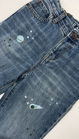 Image of jeans with a planet, comet and star graphics using Aqua EasyReflective Heat Transfer Vinyl and Dark Gray EasyReflective Heat Transfer Vinyl shown in daylight - not reflecting.