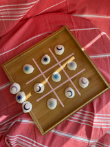 Image of a wooden tray with an outline of ‘Tic-tac-toe and shells on top decorated with logos of “Sun” and “Moons” using EasyPSV Starling in shades of Blue and Purple.