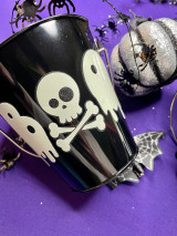 Image of black, small metal pail and the logo of “Boo” spelled in spooky symbols using EasyPSV, Glow surrounded by black spiders and a silver pumpkin in daylight.