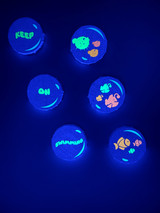 Image of six small round canvases appearing blue in the dark; different colors of Easy Glow Heat Transfer Vinyl depicting several fish and the tagline “Keep On Swimming”.