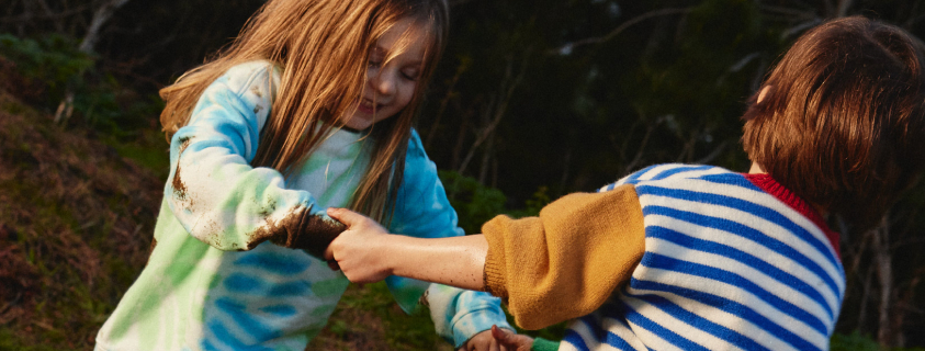 A young girl grabbing her father's leg
