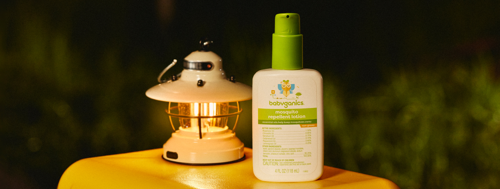 Babyganics mosquito repellent lotion next to a mosquito lamp at night