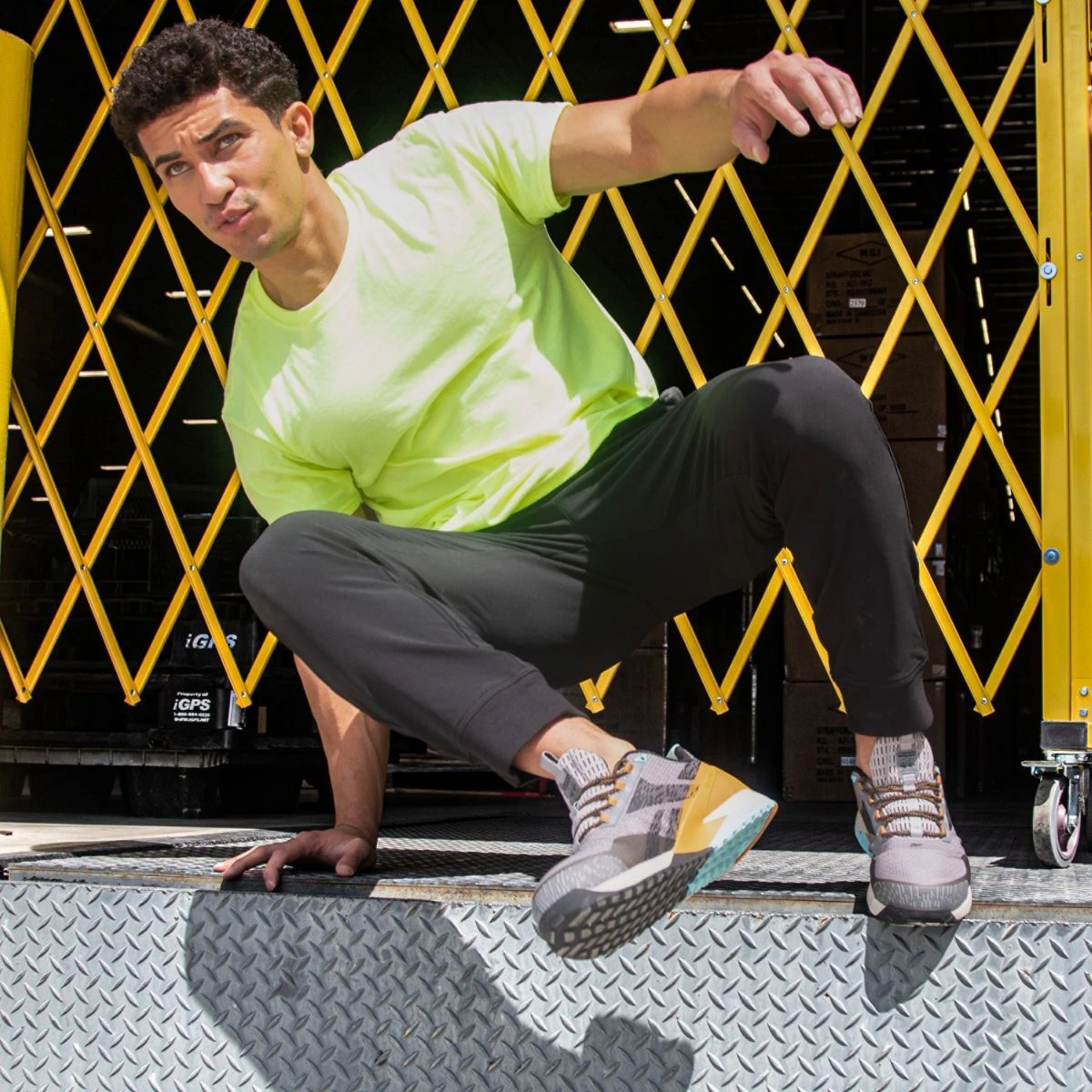 Man wearing reebok athletic safety shoes style RB3482 jumping down off of a loading zone ledge.
